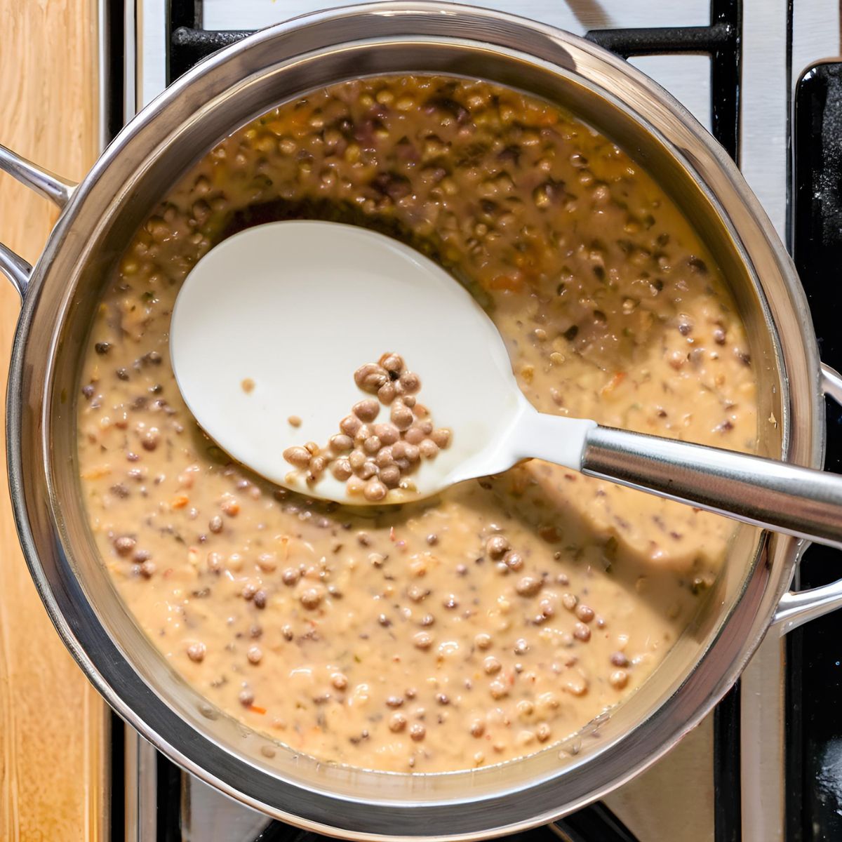 Stir cream into Dal Makhani